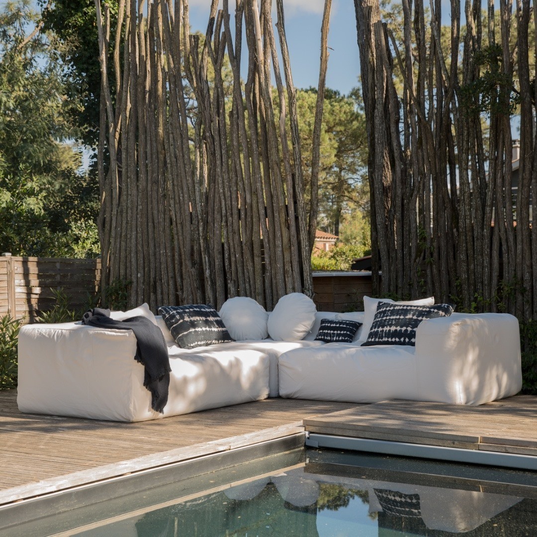 Terrasse bohème au bord de la piscine avec canapé d'extérieur